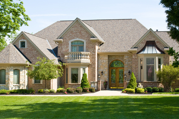 A spacious home with a well-kept, lush green lawn in front.