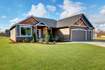 A charming home with a well-kept yard and a spacious attached garage.